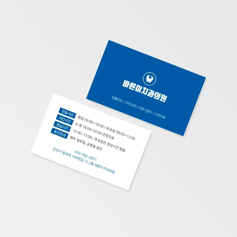 회색 배경에 남색 병원 명함과 흰 명함을 겹쳐 놓고 흰 면에 진료시간과 휴진 안내를 표로 정리한 사진