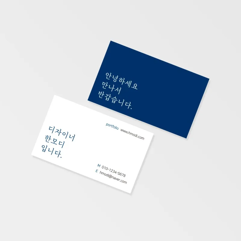 회색 배경에 남색 인사말 명함과 흰 명함을 겹쳐 놓고 흰 면에 하는 일을 세 줄로 적은 사진